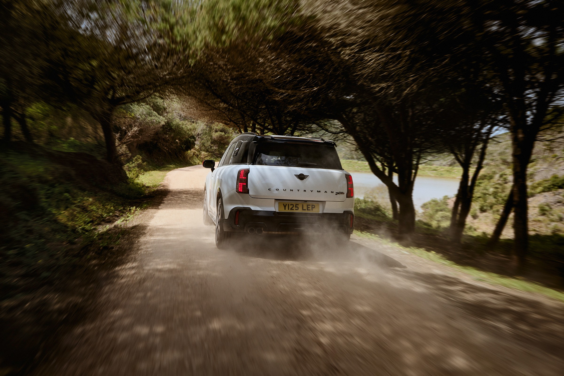 MINI Countryman num caminho de terra, visto de trás em ambiente natural 